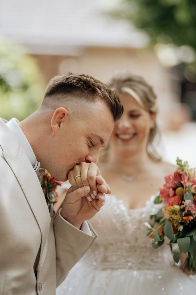 Bräutigam küsst Hand der Braut auf einer Hochzeit in Bielefeld