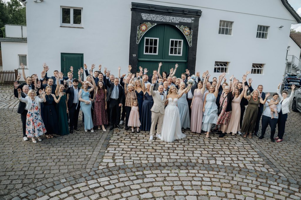 Gruppenfoto des Brautpaares mit allen Hochzeitsgästen
