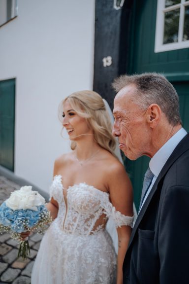 Braut mit Hochzeitsgast vor der grünen Tür des Hof Steffen