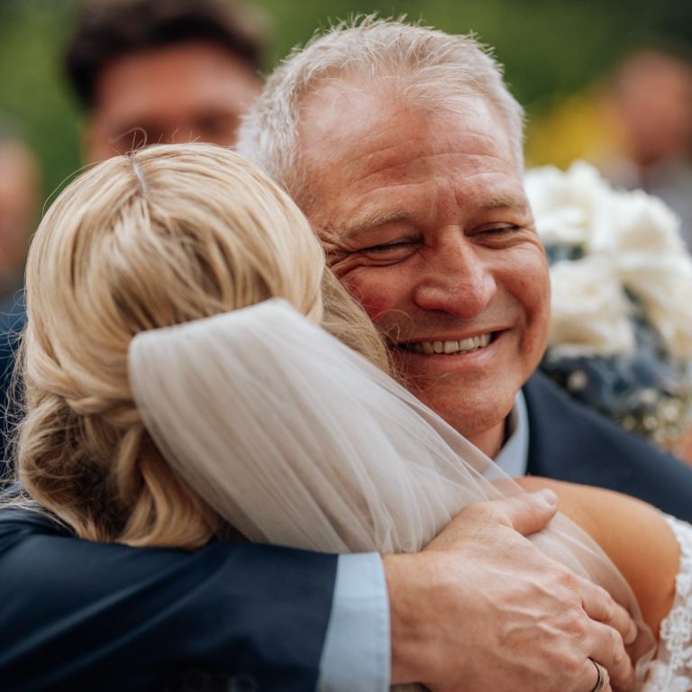 Emotionale Umarmung zwischen Braut und Brautvater bei einer Hochzeit