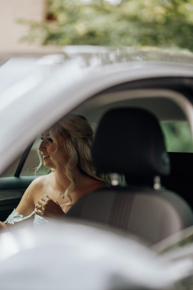 Braut sitzt vor der Hochzeit im Auto
